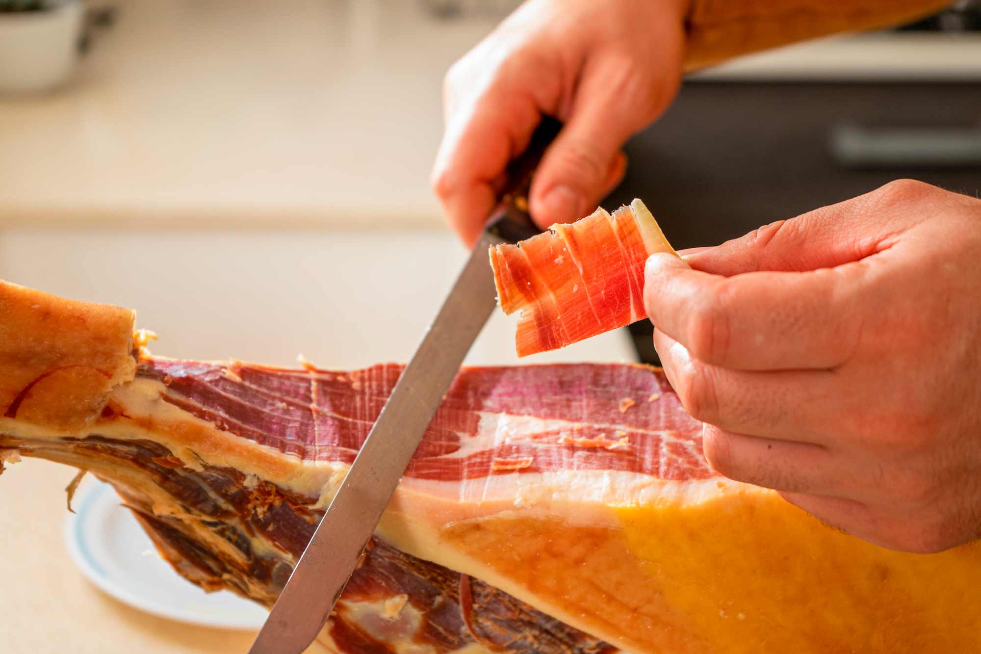 Persona cortando lonchas de jamón ibérico